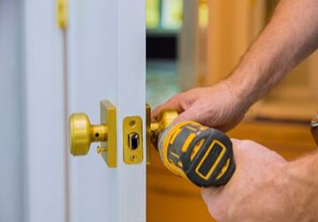 Person installing a door handle with drill.